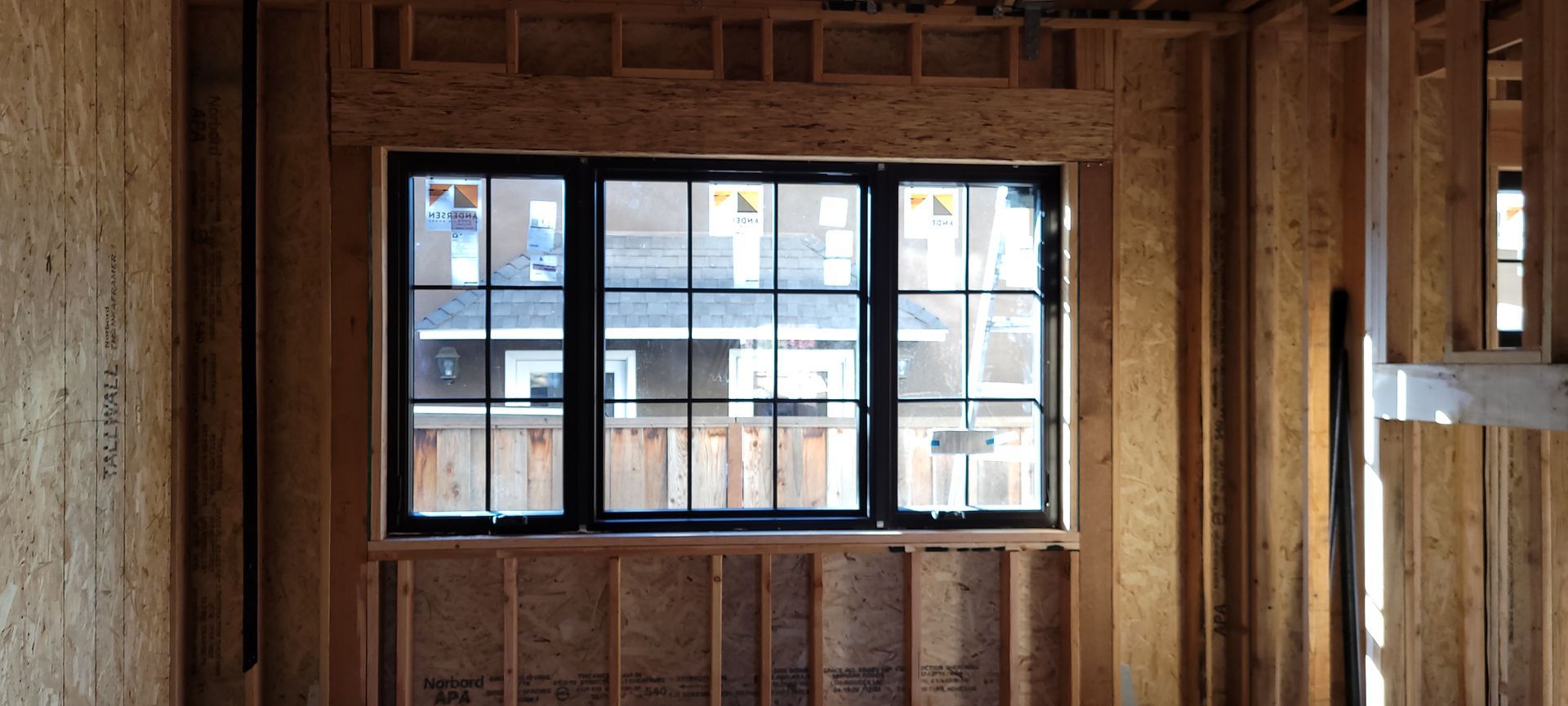 Interior view of a new home under construction, with a window and wooden framing visible.