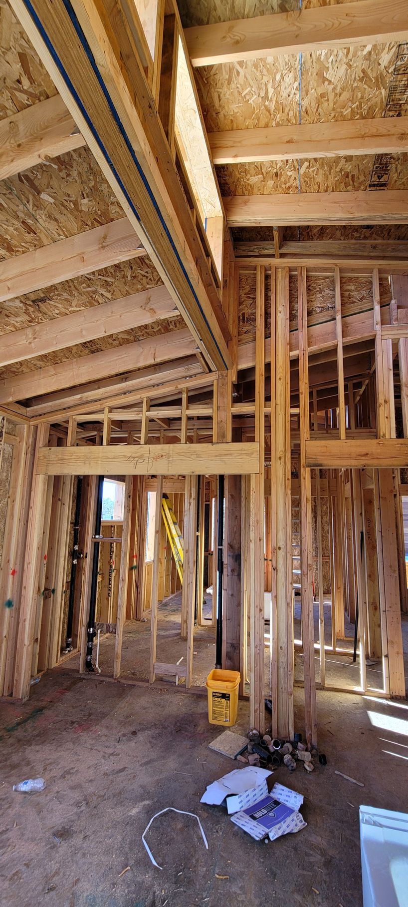 Interior view of a building under construction, showing wooden framing for walls and ceiling