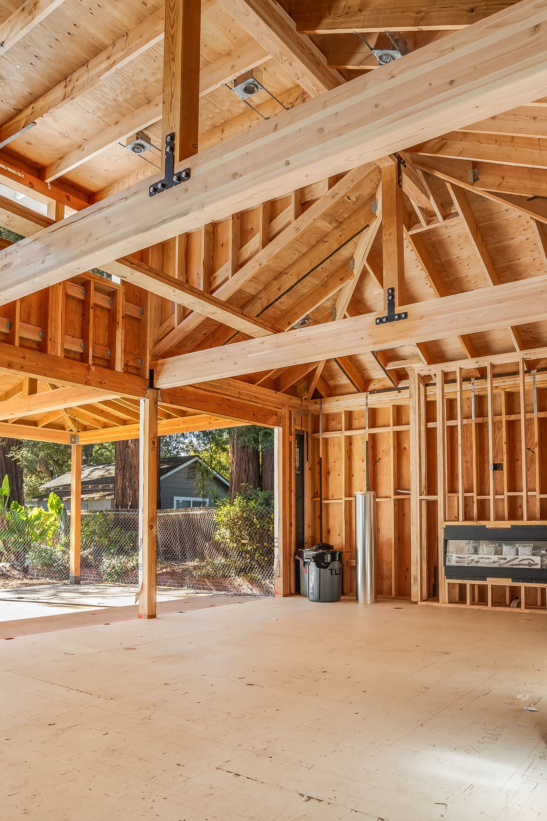 Interior view of a new home under construction with exposed wooden beams and framing.
