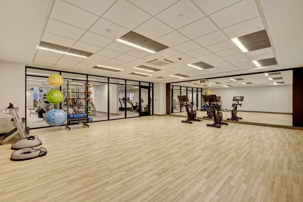 A large gym with a lot of mirrors and exercise equipment.
