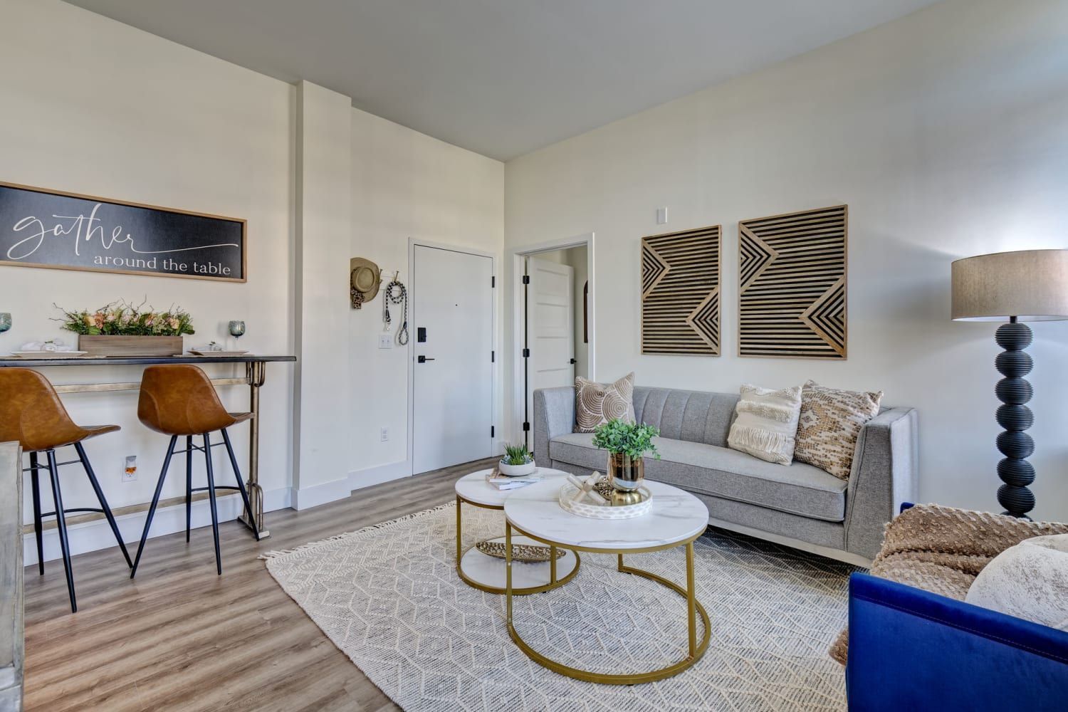 A living room with a couch , two coffee tables , and a bar.