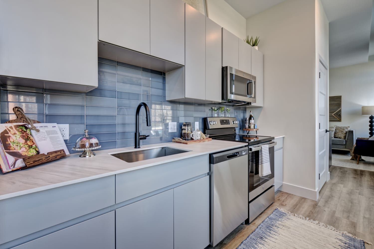 A kitchen with stainless steel appliances , a sink , and a microwave.