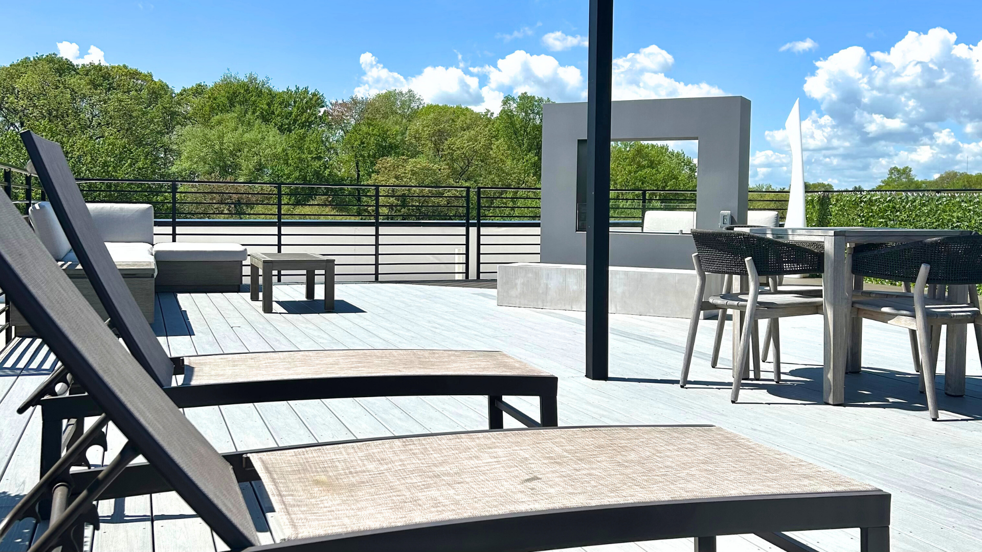 A rooftop lounge with chairs and tables.