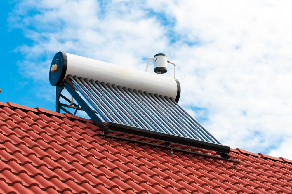 A Solar Water Heater is Sitting on Top of a Red Tiled Roof