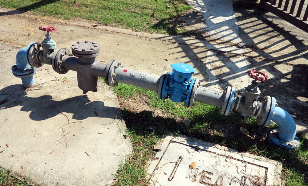 A Water Pipe is Sitting on the Sidewalk Next to a Sign That Says Area