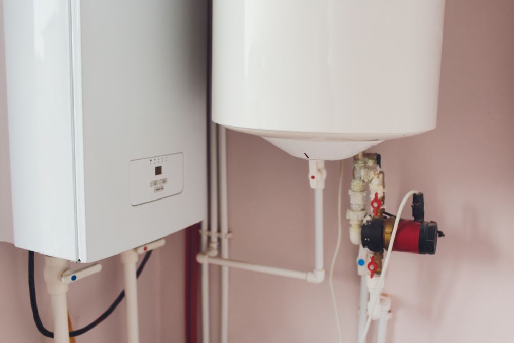 Two White Water Heaters Are Sitting Next to Each Other in a Room — Absolute Plumbing Australia in Darwin Region, NT