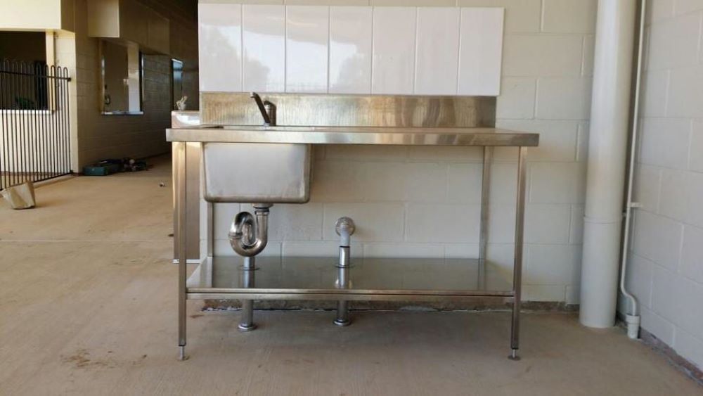 A Stainless Steel Table With a Sink Underneath It — Absolute Plumbing Australia in Howard Spring, NT