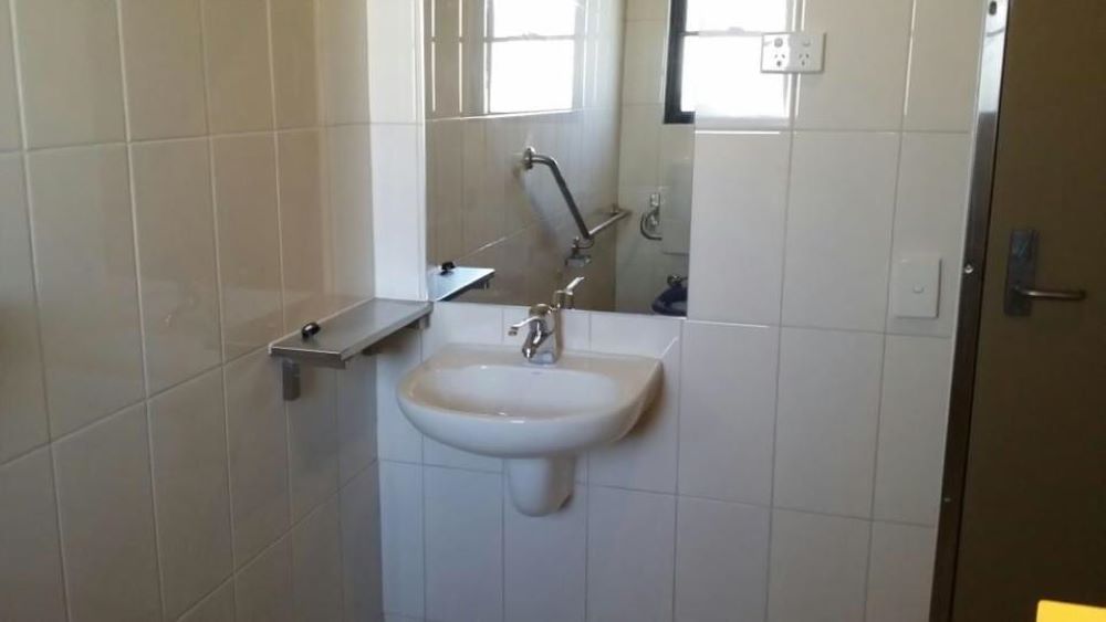A Bathroom With a Sink and a Mirror — Absolute Plumbing Australia in Howard Spring, NT