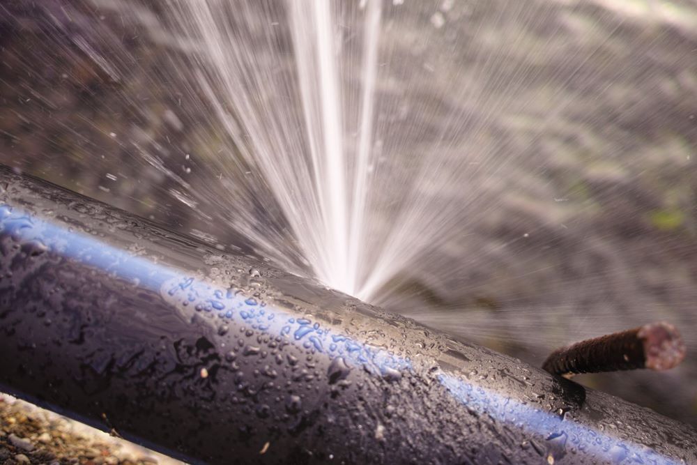 A Pipe is Bursting With Water Coming Out of It — Absolute Plumbing Australia in Leanyer, NT