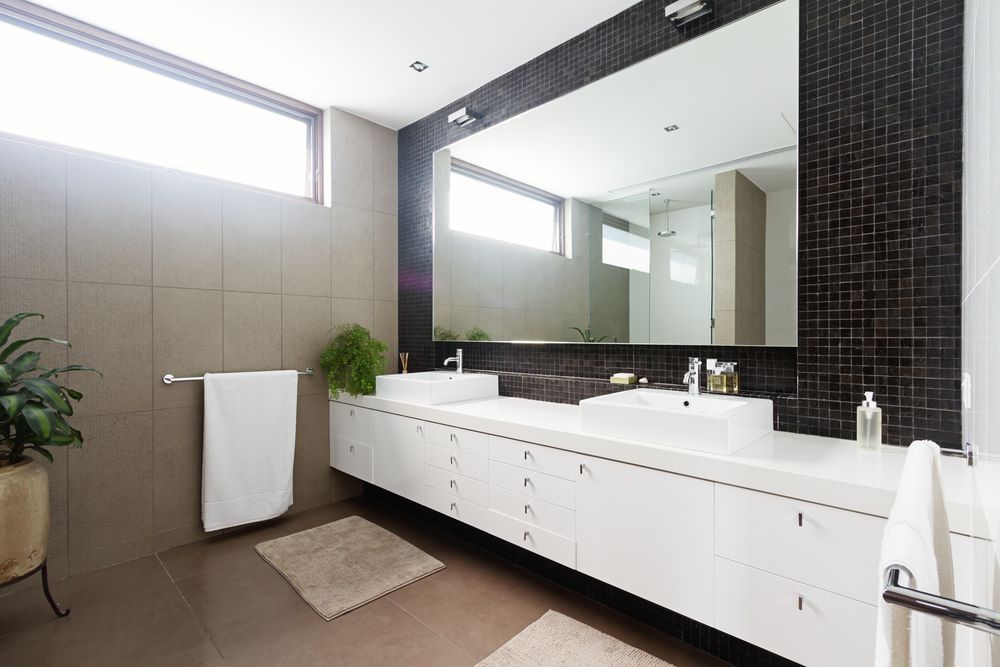 A Bathroom With Two Sinks and a Large Mirror — Absolute Plumbing Australia in Leanyer, NT