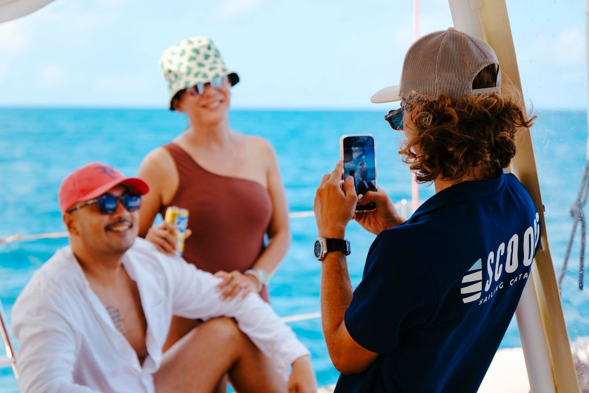 Des personnes sur un bateau posent pour une photo. La mer est en arrière-plan.