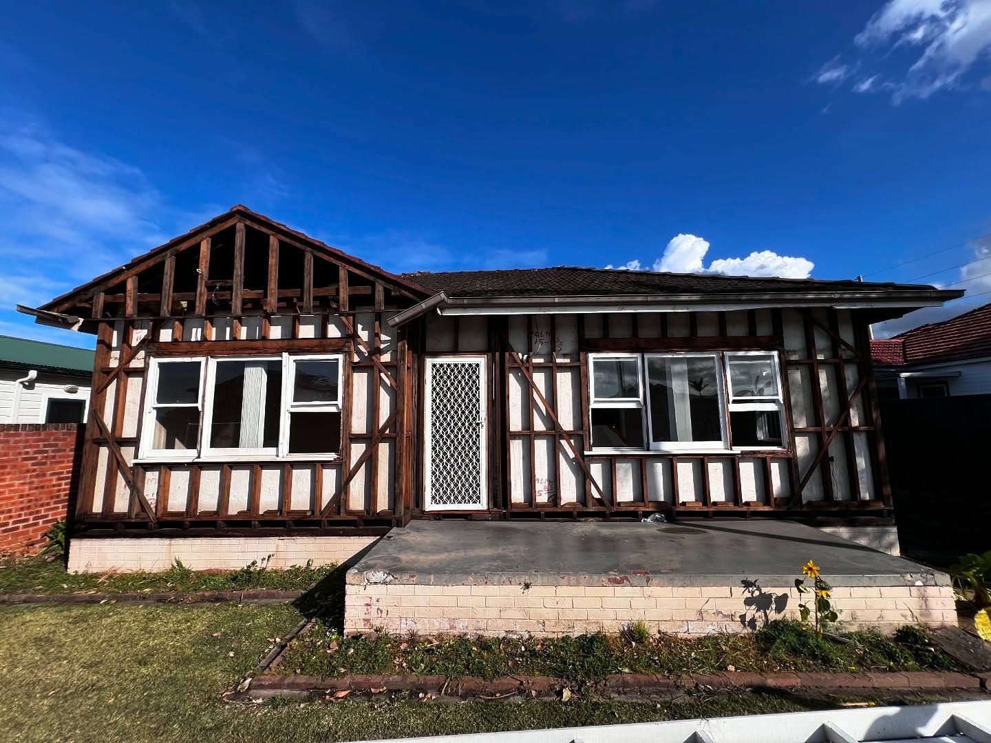 House With Exposed Wooden Framework; Tudor Style Facade, Blue Sky — Ecowave Solutions Asbestos Removal In Gosford, NSW