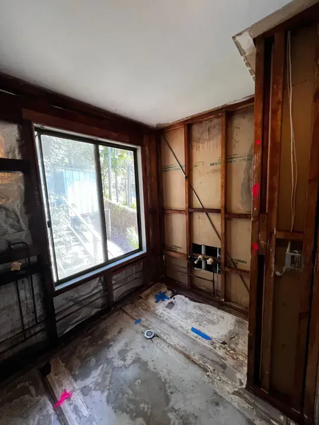Bathroom Under Renovation With Exposed Studs, Window, and Debris on the Floor —  Ecowave Solutions Asbestos Removal In Gosford, NSW