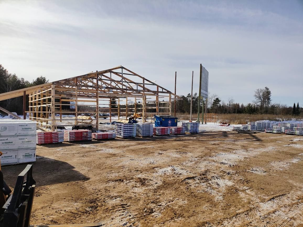 A large building is being built in the middle of a dirt field.