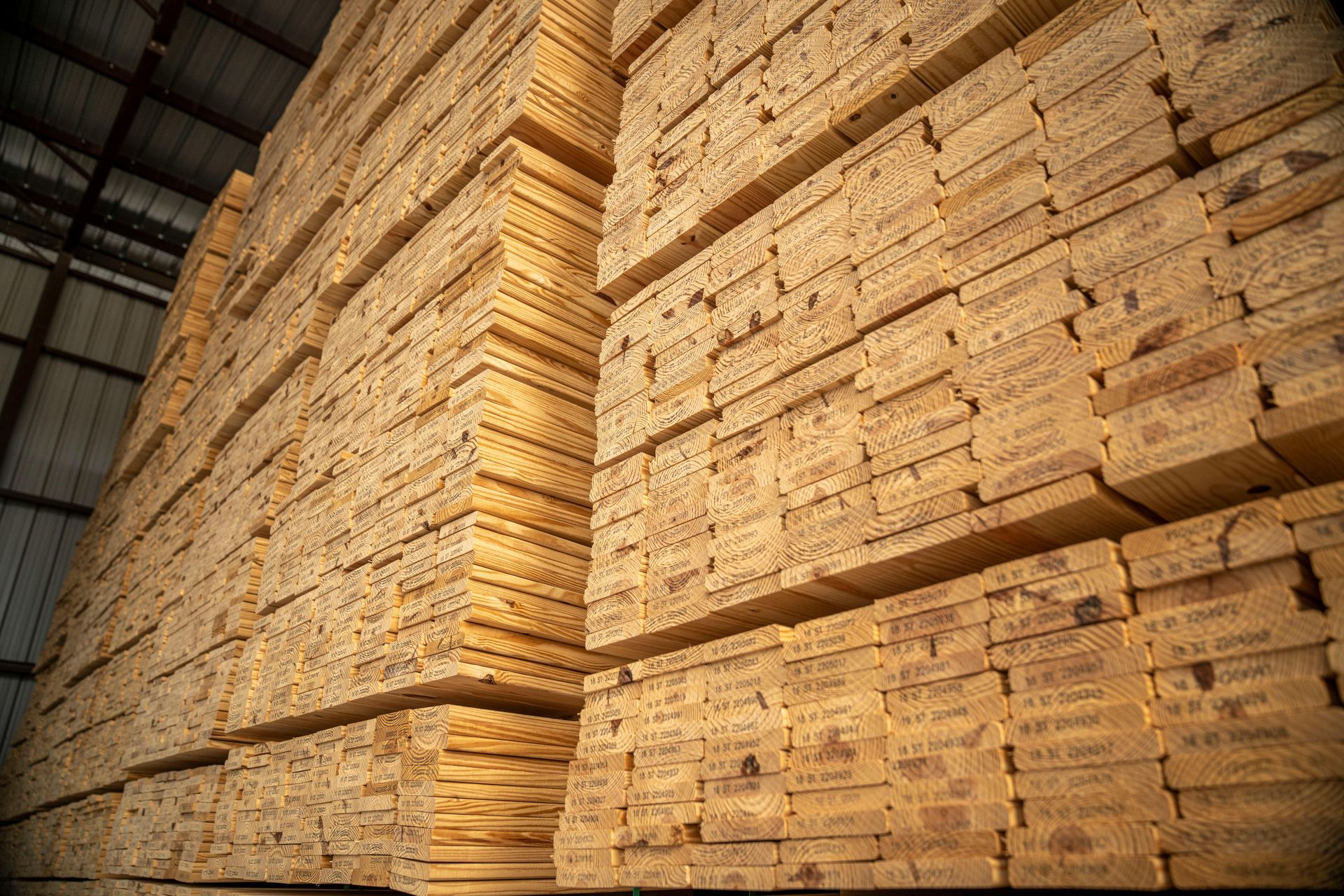 A warehouse filled with lots of wooden boards stacked on top of each other.