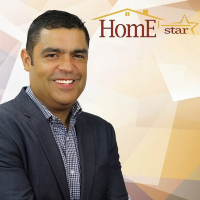 A man in a suit is smiling in front of a home star logo.
