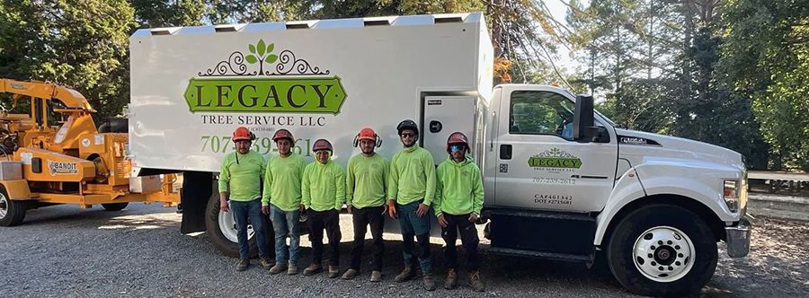 a group of men are standing in front of a legacy truck .