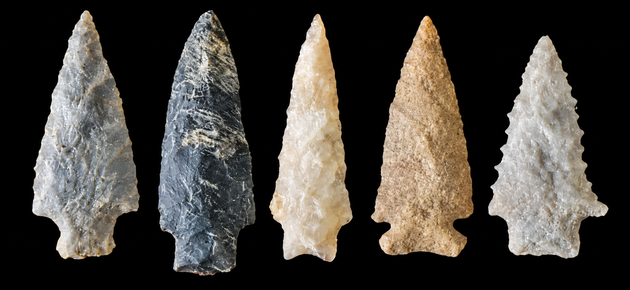 Elderly hands unwrapping bubble-wrapped arrowheads from an inherited collection