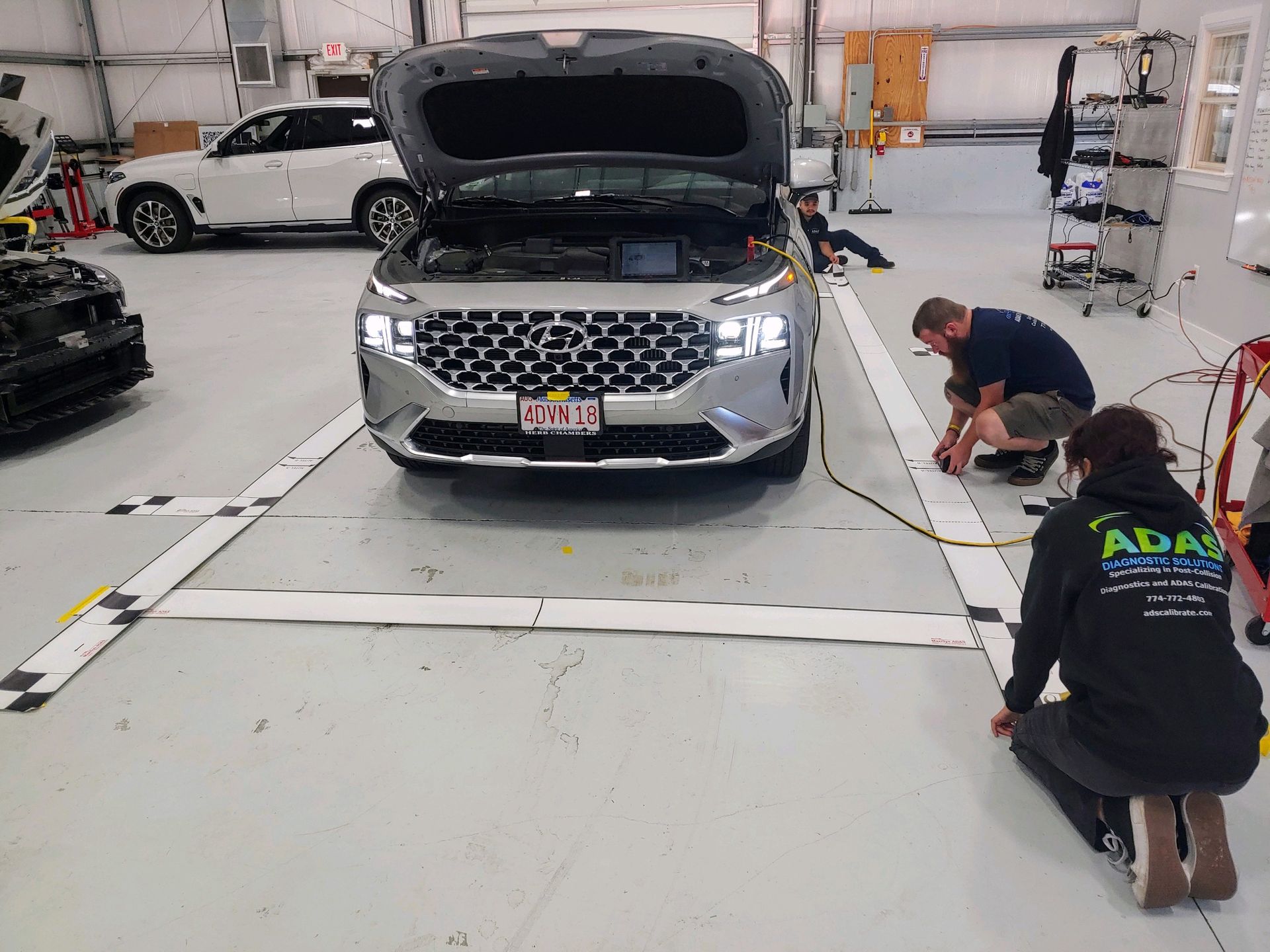 A group of people are working on a car in a garage.