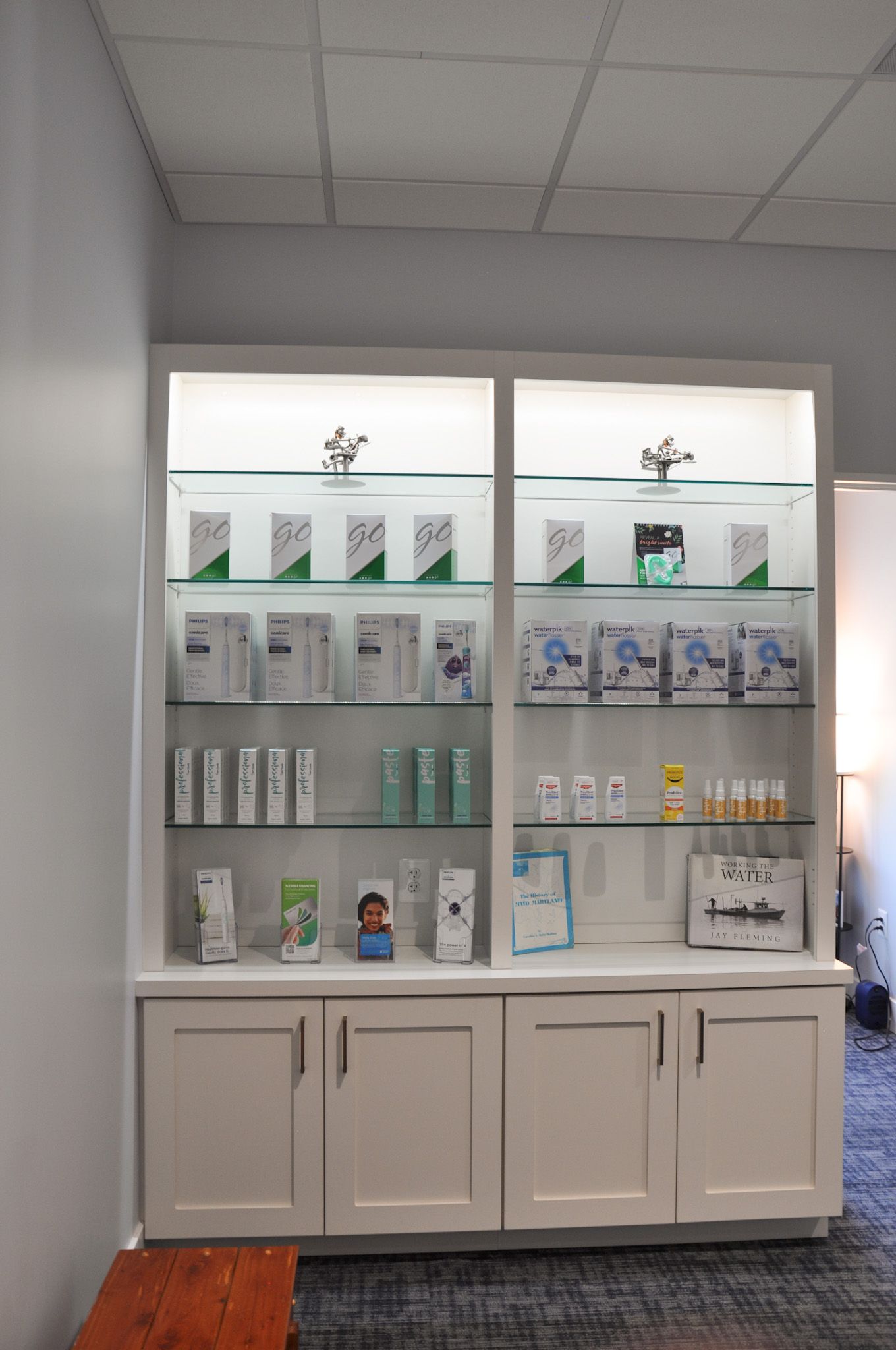 White display cabinet with shelves of products, under bright overhead lighting.