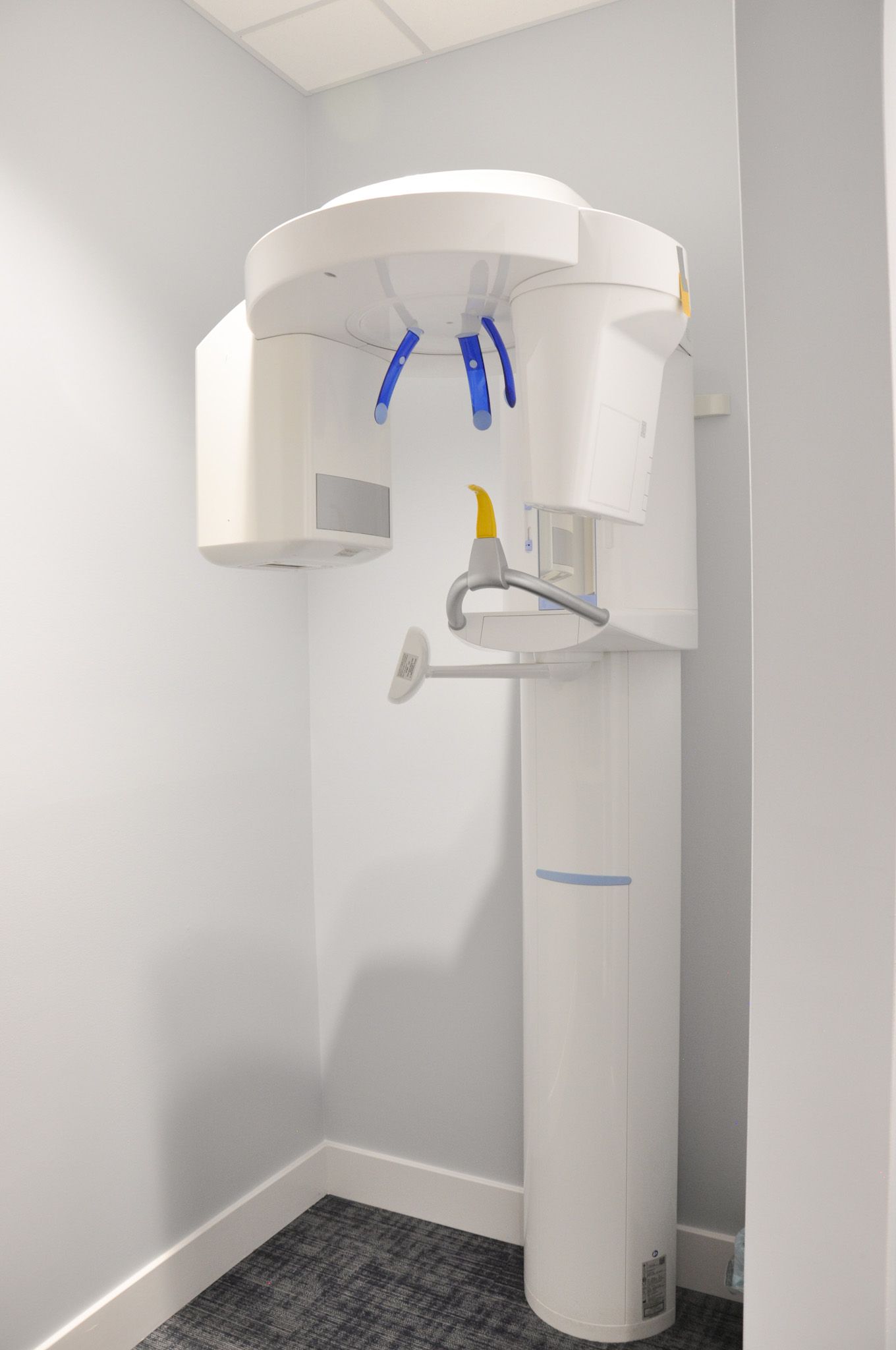 Panoramic dental X-ray machine in a dentist's office. White and blue device, mounted on the wall.