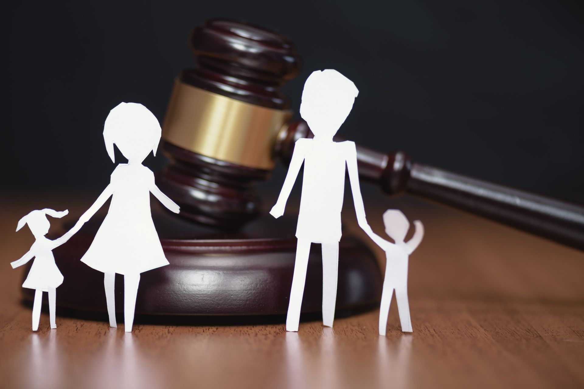 Family silhouettes beside a judge’s gavel, symbolizing custody or family law.