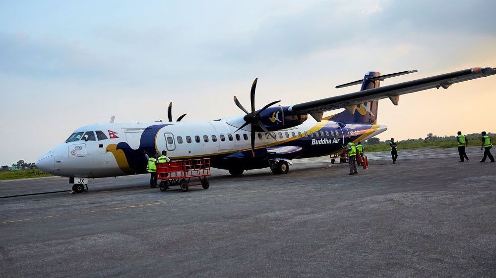 Buddha Air airplane on the tarmac, showcasing air travel as an option for reaching Pokhara from Kathmandu in Nepal.