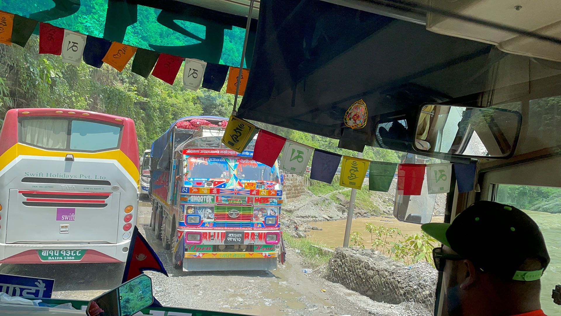 View of colorful buses lined up on a road, illustrating the popular transport route from Kathmandu to Pokhara in Nepal.