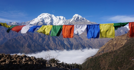 Prayer flags above a sea of clouds, with snow peaks of the Annapurna range on the Poon Hill trek