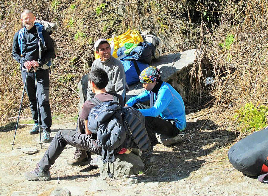 Porters and trekkers interacting, showcasing the camaraderie and support vital for trekking in the Annapurna region of Nepal.