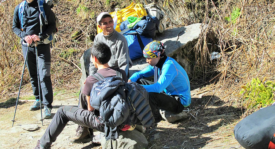 Local helpers resting on the trail during a private guided trek in the Annapurna region, Nepal