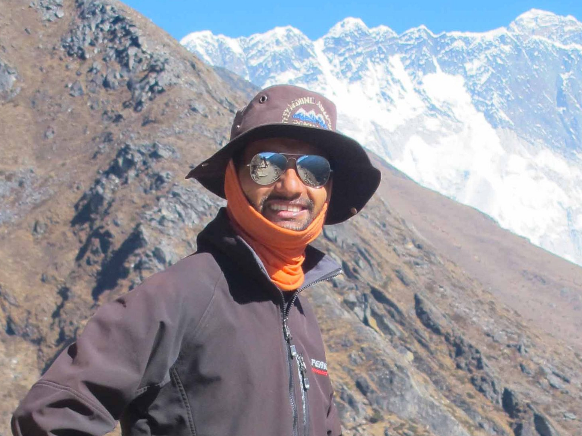 Licensed trekking guide in Nepal smiling outside a mountain lodge during a Himalayan trekking adventure.