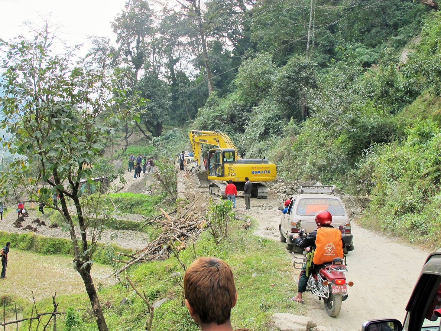A traffic jam on the way to Pokhara in Nepal, showcasing road construction along with motorbikes and cars.