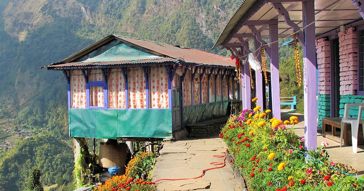 Colorful lodge adorned with flowers, providing a welcoming atmosphere for trekkers on the Annapurna Base Camp Trek in Nepal.
