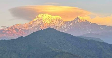 Annapurna South and Hiunchuli in golden light above the forested hills near Dhampus