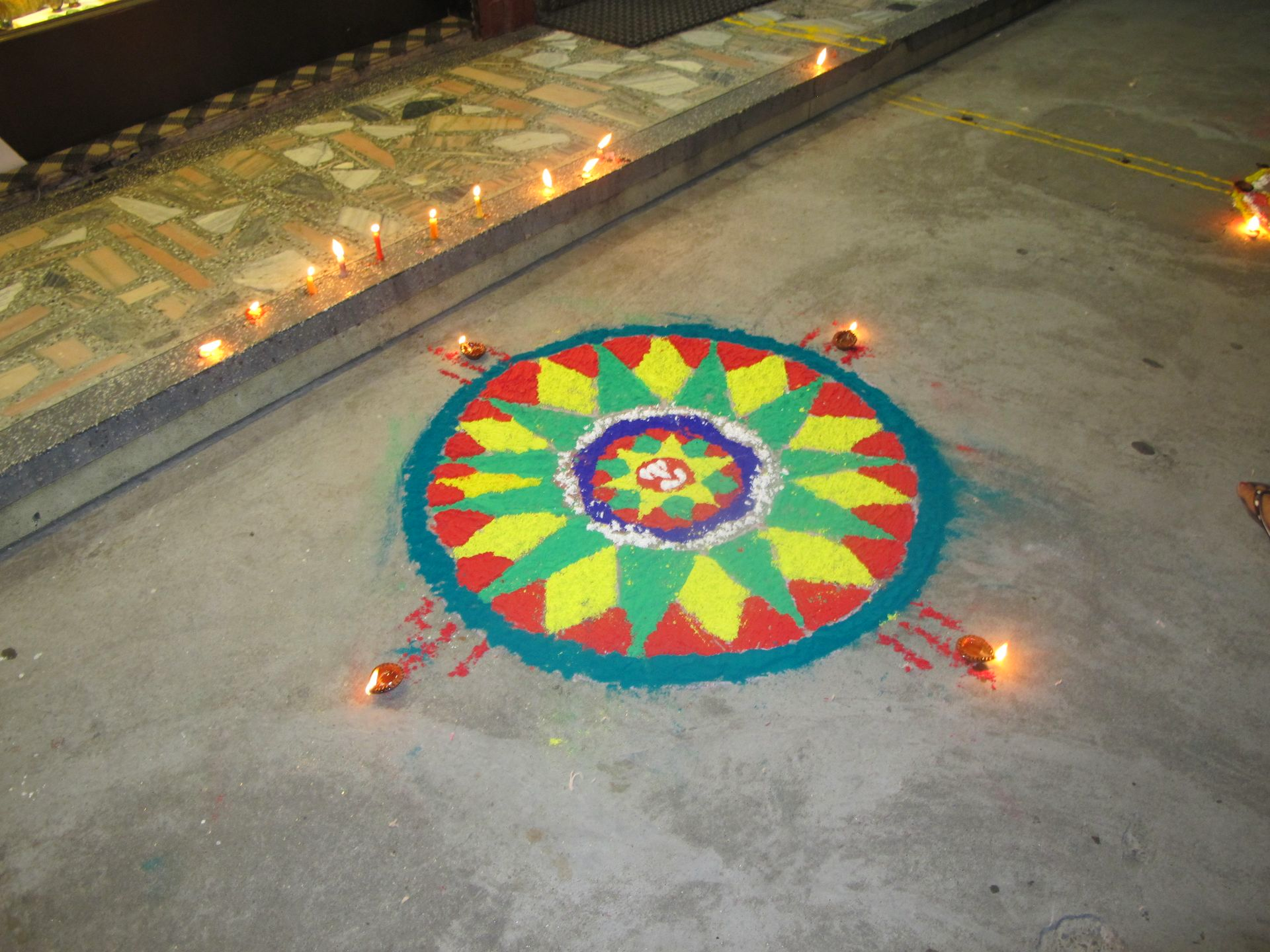 Small oil lamps leading to a flower rangoli, a path of light to welcome Laxmi on Tihar