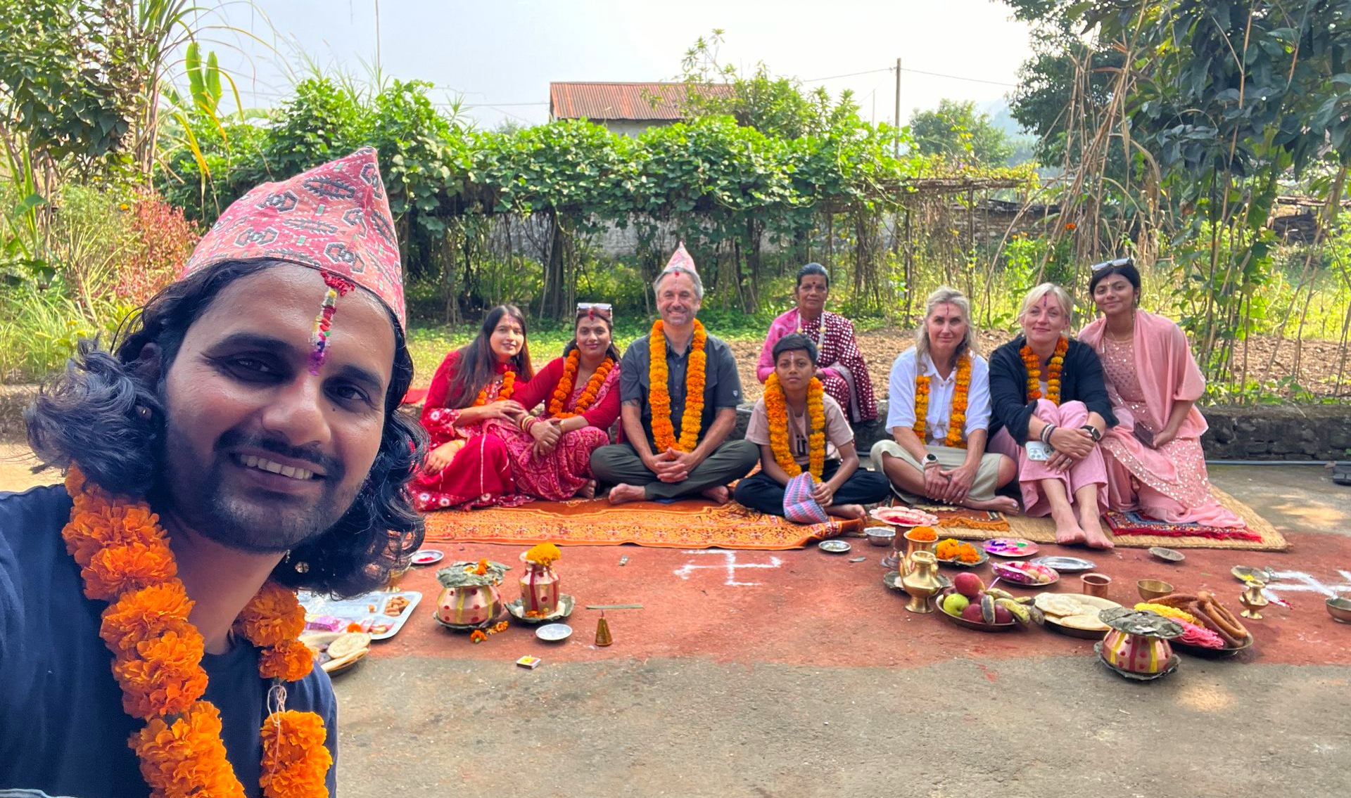 Trekking guests sitting with a Nepali family during a Tihar celebration