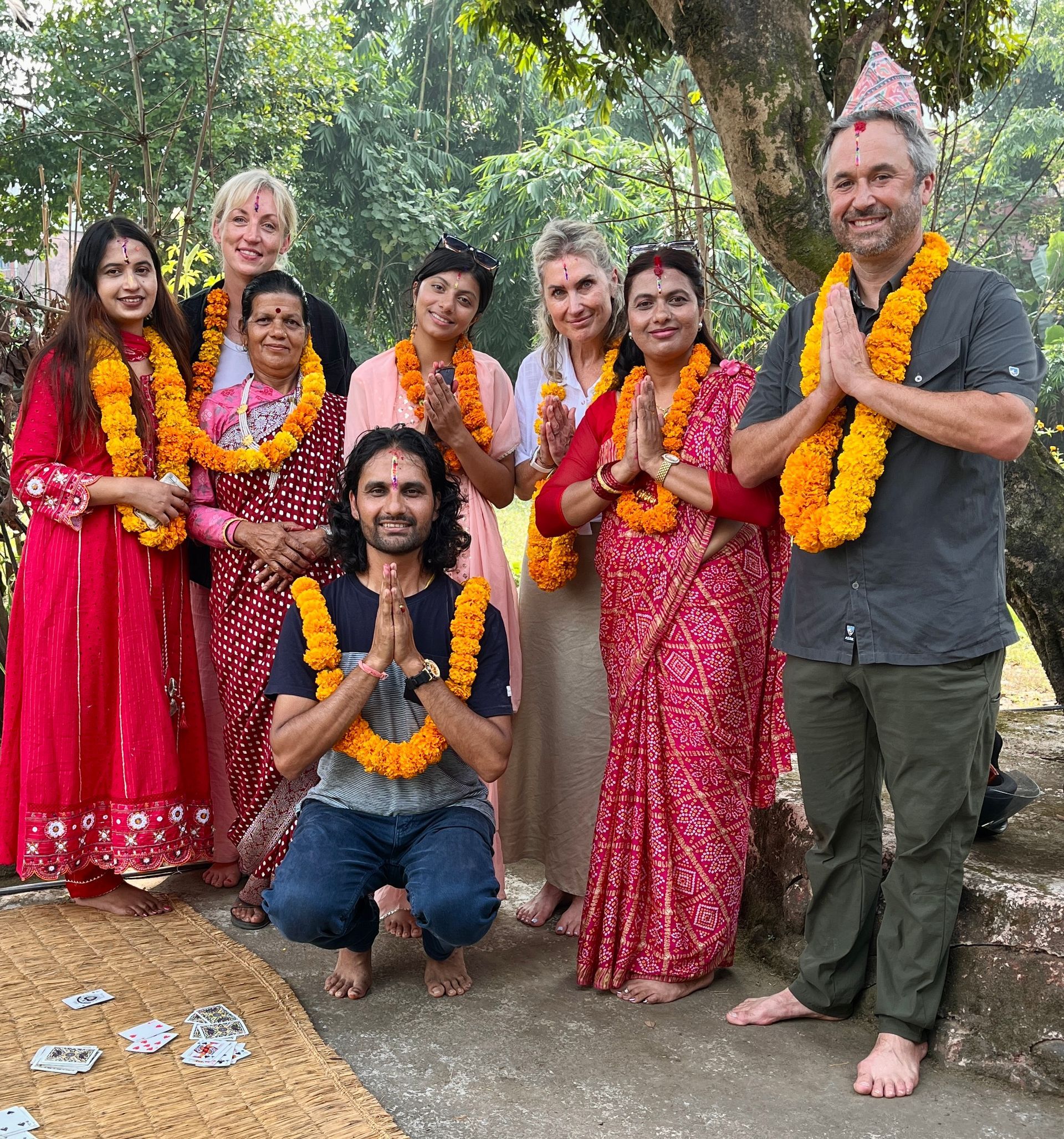 Trekking guests and a Nepali family with marigold garlands and colourful tika during Tihar