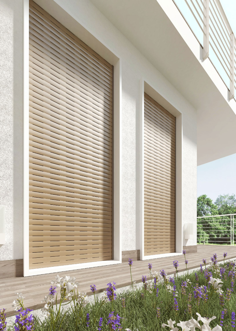 Esterno di un edificio moderno con persiane beige e fiori viola lungo il vialetto.