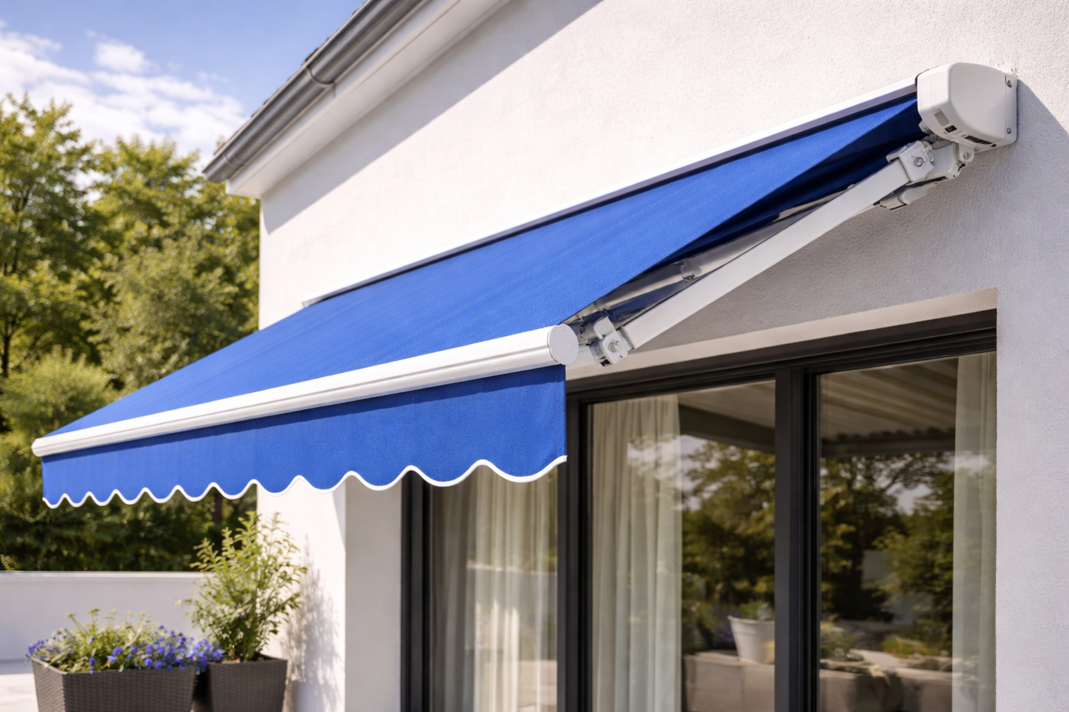 Tenda da sole blu retrattile sopra una finestra e una porta-finestra di una casa bianca