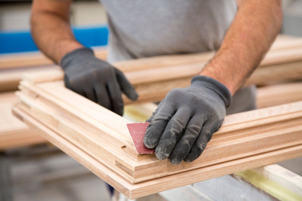 Person Sanding a Wooden Frame, Wearing Gloves — Kalora Carpentry & Restorations in Merewether, NSW