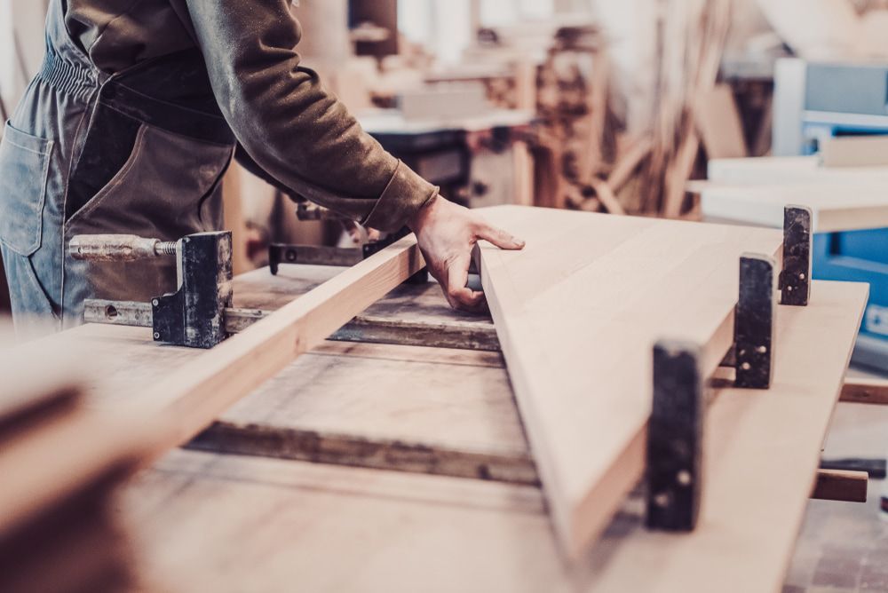 Carpenter Clamping Wooden Pieces Together in a Workshop — Kalora Carpentry & Restorations in Charlestown, NSW