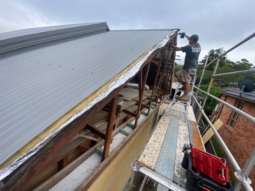 Man on Scaffolding Installing Metal Roofing on a House — Kalora Carpentry & Restorations in Charlestown, NSW