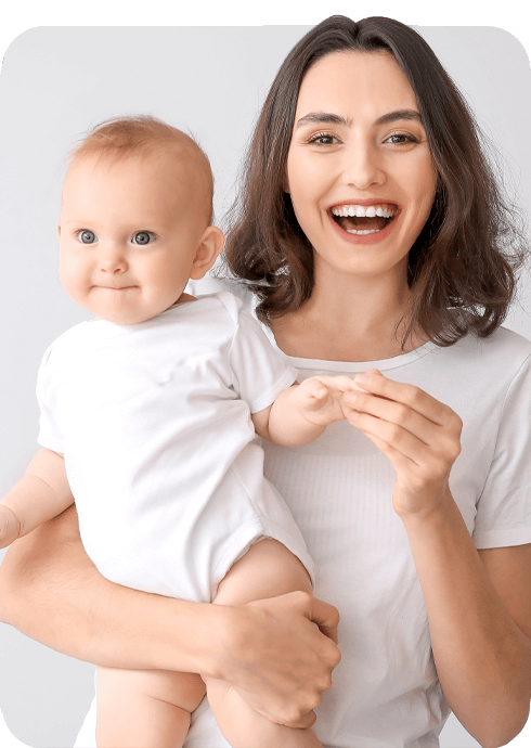 Smiling woman holding a baby against a white background