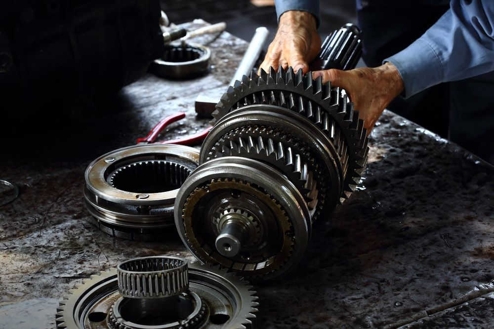 Mechanic Hands Fixing Engine Power Transmission Gears Box — Crossway Wreckers & Mechanical In Gordonvale, QLD