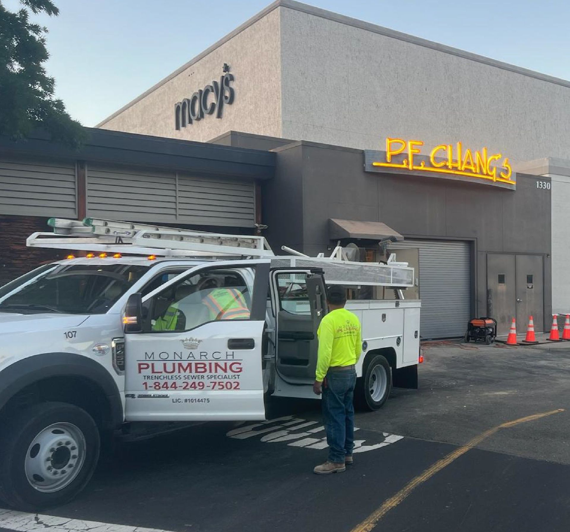 Monarch Plumbing service van in Hayward CA and worker outside a Macy’s store at a mall parking lot