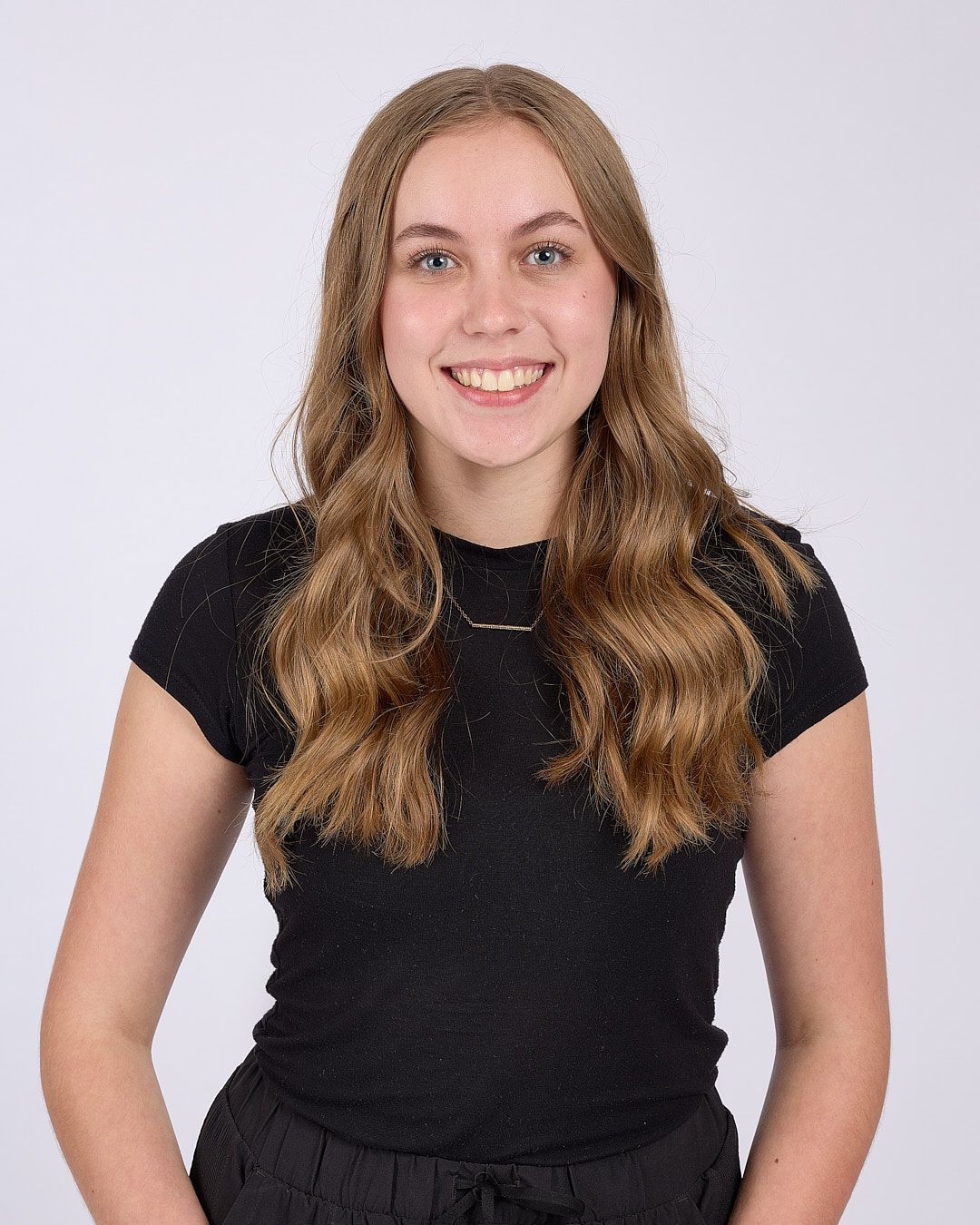 Smiling person in a black T-shirt against a light gray background