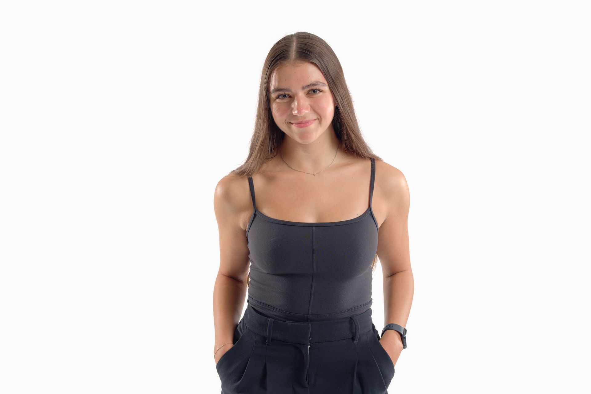 Person in a dark sleeveless top smiling against a white background