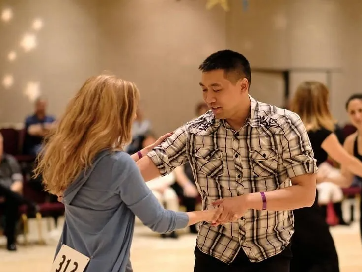 Westie Kim dancing with student at a West Coast Swing event