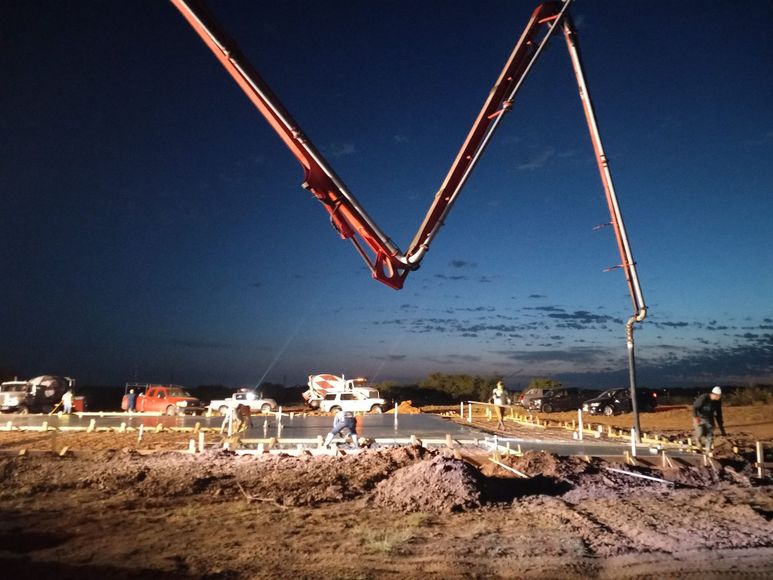 A concrete pump is being used to pour concrete on a construction site
